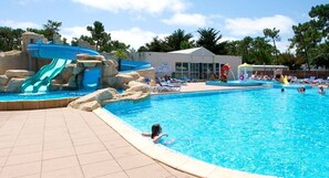Una piscina al aire libre de temporada, sillones reclinables de piscina