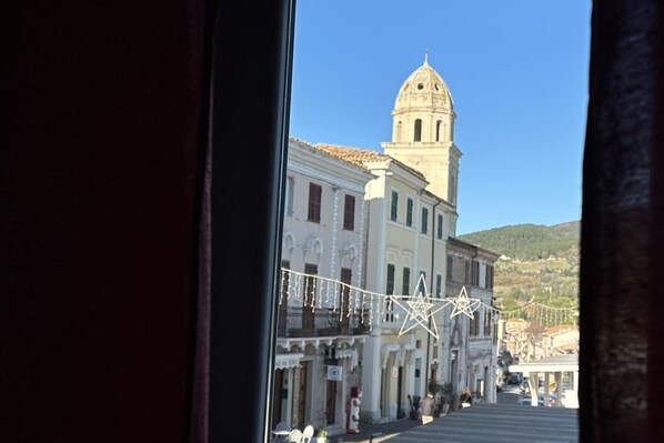 A street view with a prominent building featuring a dome and a bell tower.