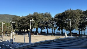 Ein Park am Meer mit Sitzgelegenheiten, Bäumen und freiem Blick auf das Wasser.