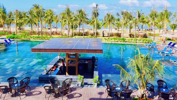 A pool area with lounge chairs, a bar, and a view of the beach. - Sonaga Beach Resort & Villas Phu Quoc (Phu Quoc)