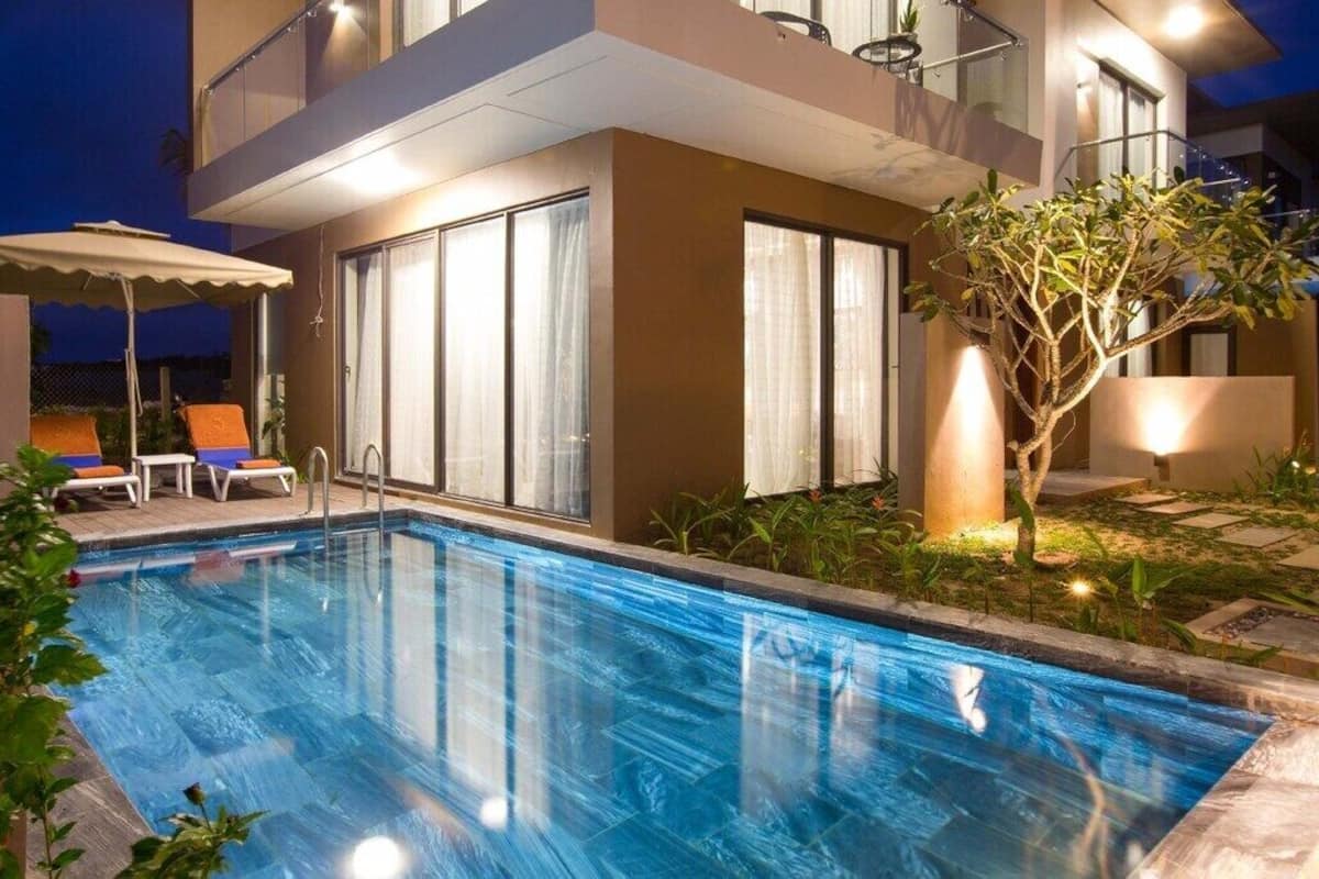 Un hôtel moderne doté d’une piscine, d’un espace extérieur aménagé et d’un balcon bien éclairé.