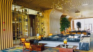 A spacious lobby with a central seating area, a large plant, and a modern chandelier. - Sonaga Beach Resort & Villas Phu Quoc (Phu Quoc)