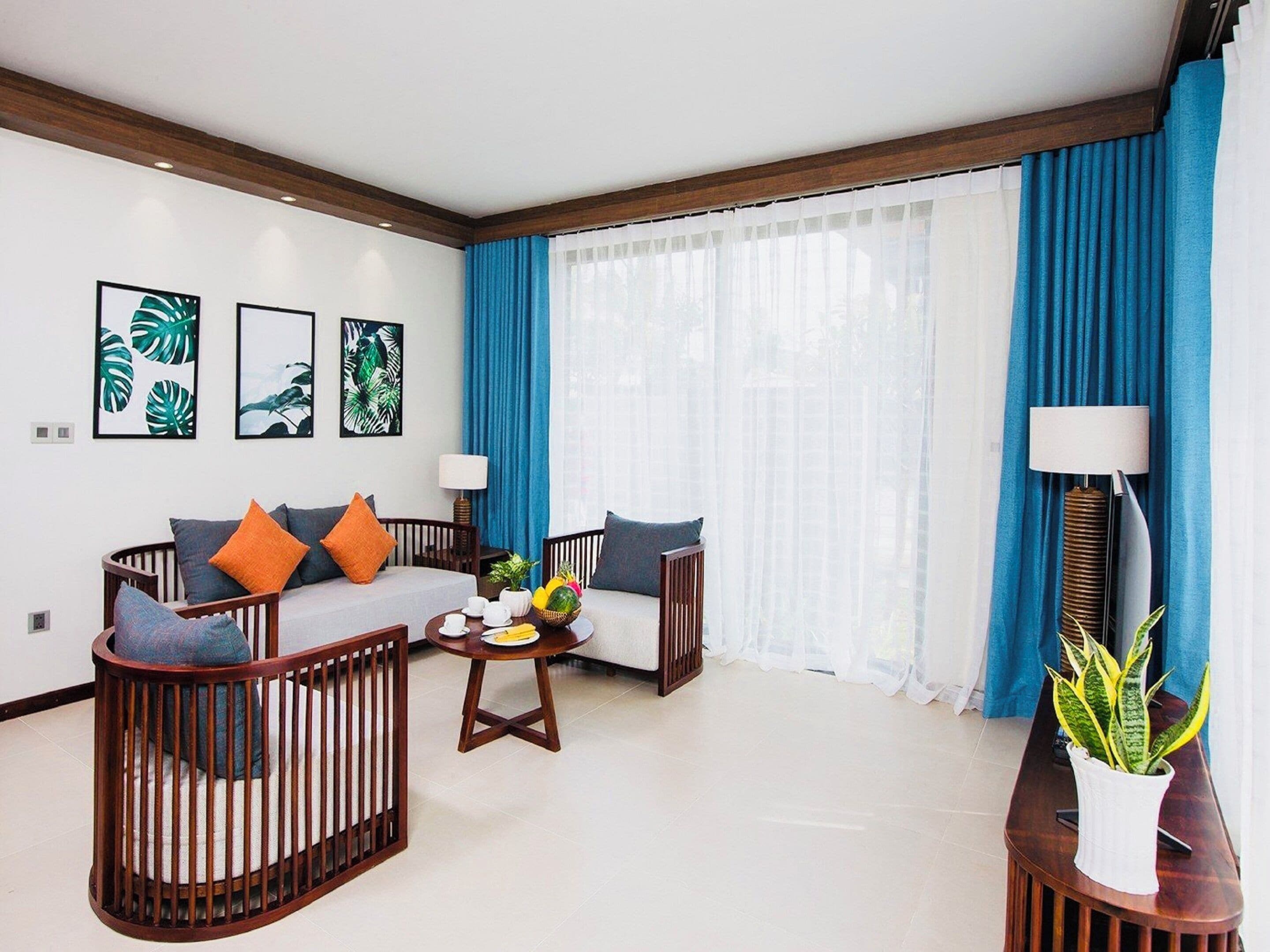 A modern living room with a sofa, two armchairs, a coffee table, and a side table with a plant.