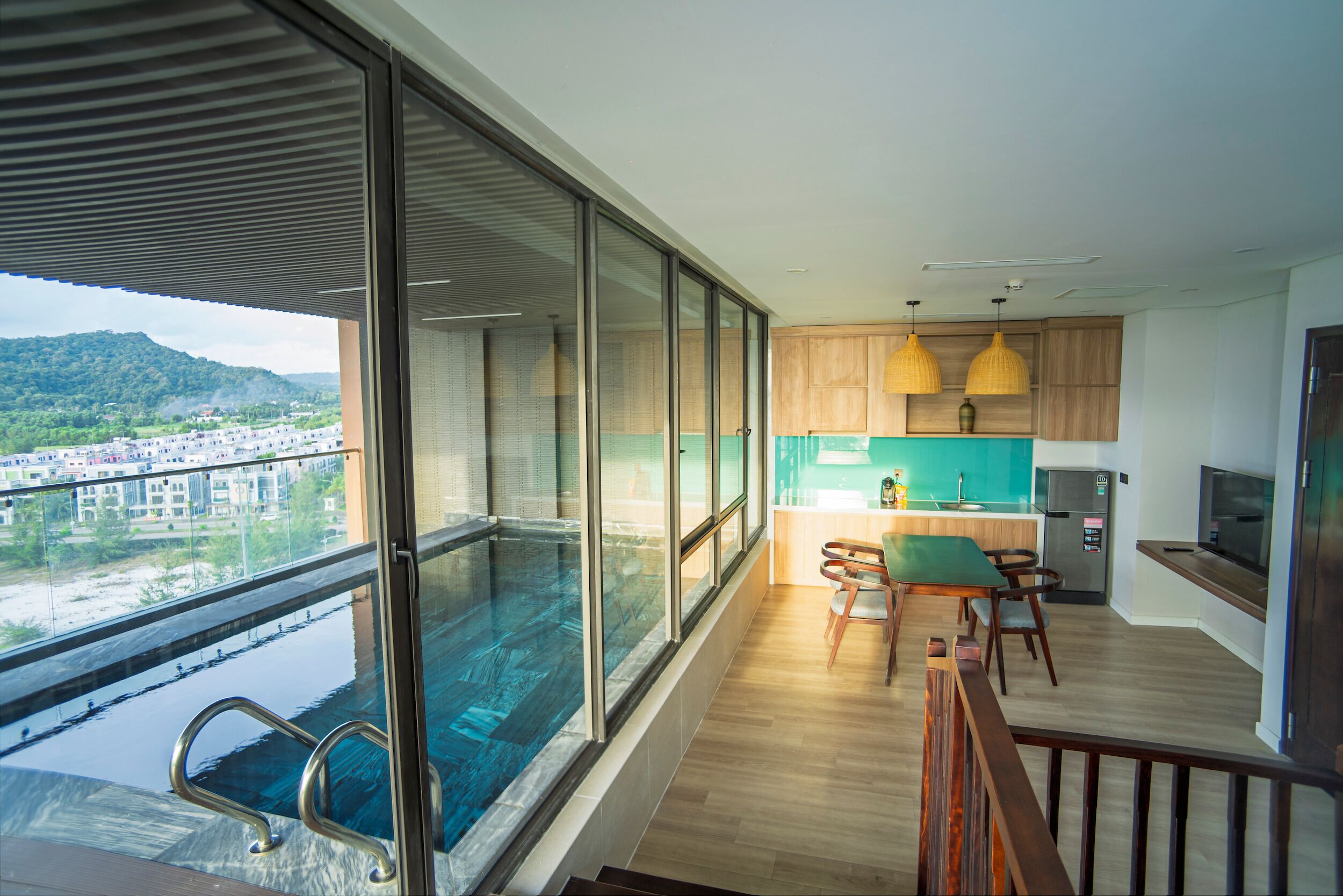 A modern apartment with a balcony, a kitchen, and a dining area.