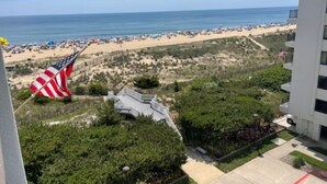 En vy över en strand med en flagga, en byggnad och en klar himmel.