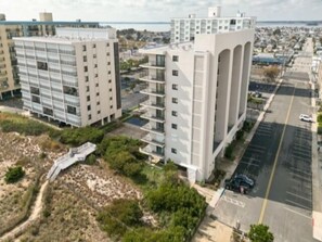 Ein modernes, mehrgeschossiges Gebäude mit Parkplatz und Blick auf das Meer.