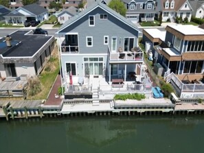 A two-story house with a dock, a balcony, and a front porch.