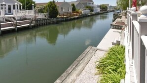 Una vía fluvial tranquila con un muelle, un edificio pequeño y una casa al fondo.