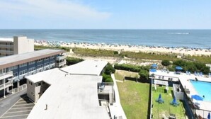 Un hôtel doté d’une piscine sur le toit, offrant une vue sur la plage et disposant d’un parking.