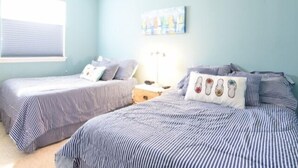 A bedroom with two beds, a ceiling fan, a window with blinds, and a painting on the wall. - Ocean Block Condo, porch, 1st floor, steps to beach, updated, full kitchen, lg dining table, wifi! (Ocean City)