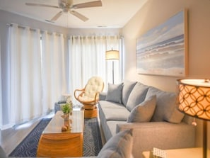 A modern living room with a sofa, a chair, a coffee table, and a lamp.