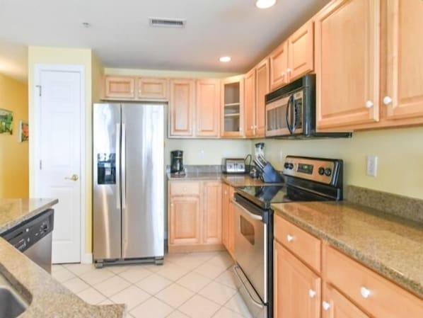 Kitchen area with a refrigerator, microwave, and toaster.
