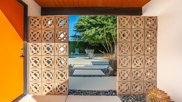 A wooden gate with a geometric pattern leading to a pool area. - Stylish Mid Century Krisel Oasis -New pool deck, Salt Water Pool, Firepit, BBQ (Palm Springs)