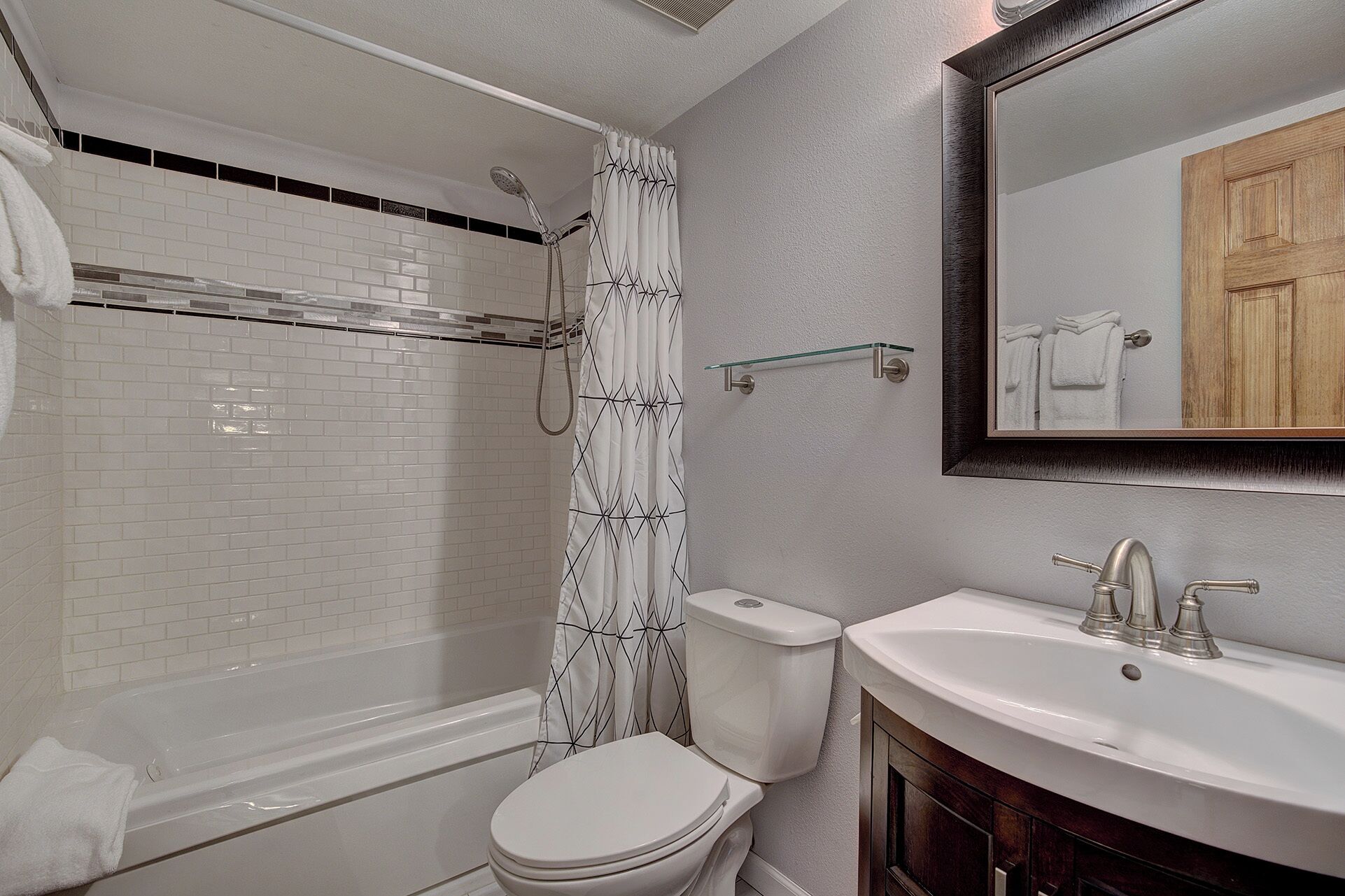 A bathroom with a bathtub, toilet, and sink.
