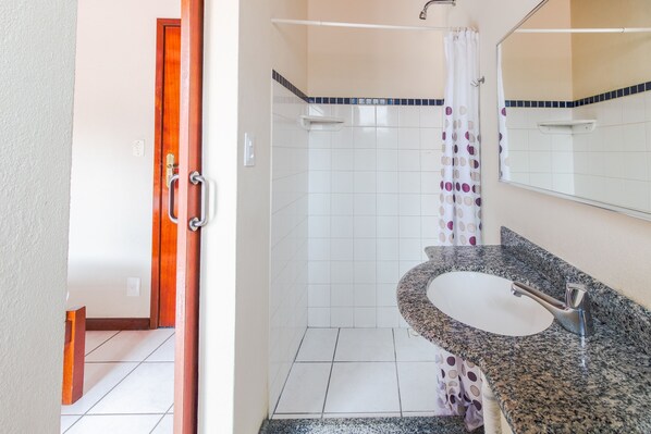 Habitación doble | Baño | Ducha, toallas y papel higiénico