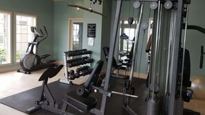 Une salle de sport équipée de machines d’exercice, d’un tapis de course et d’haltères.
