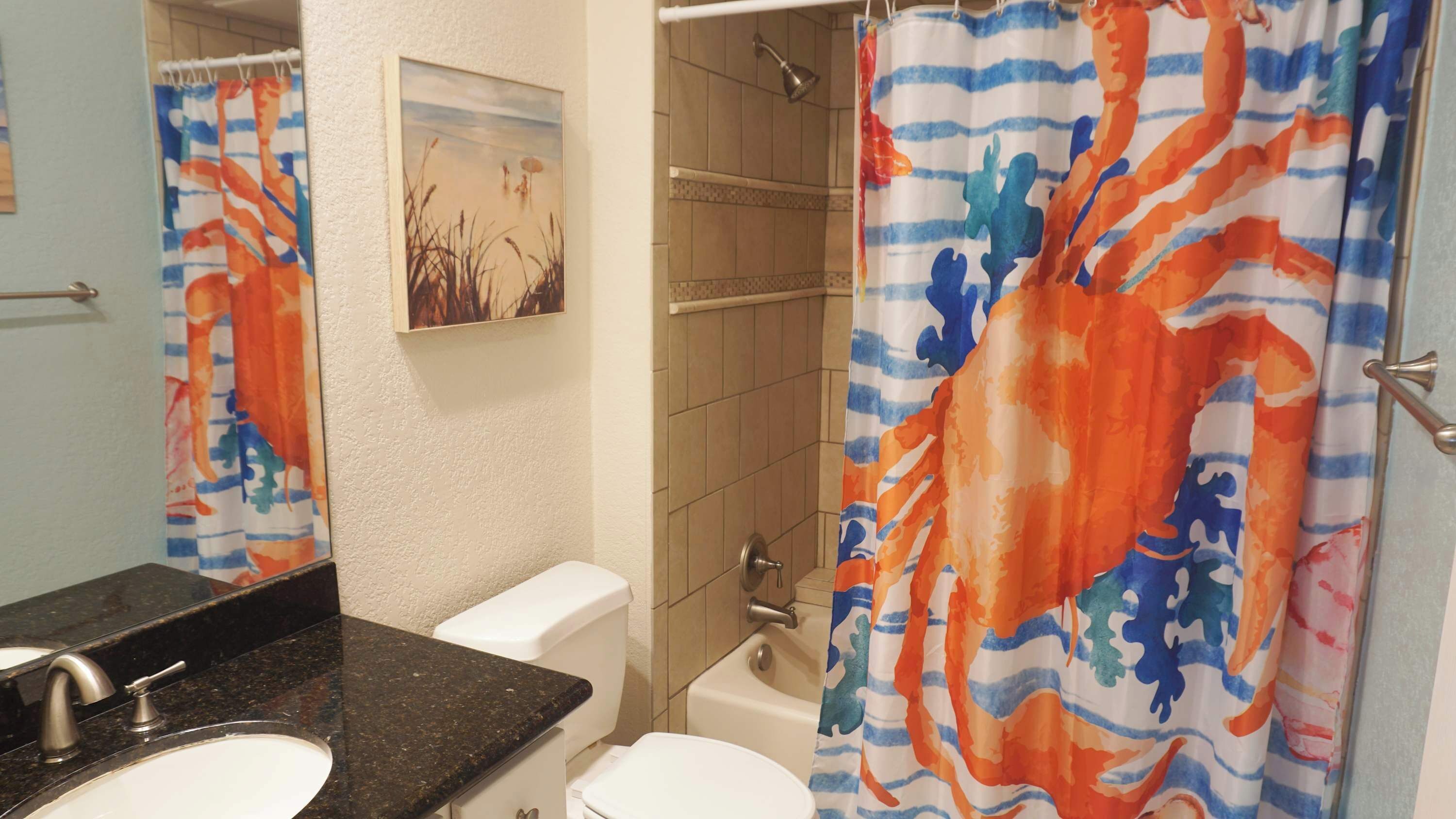 Ein Badezimmer mit Dusche, Toilette, Waschbecken und Spiegel.