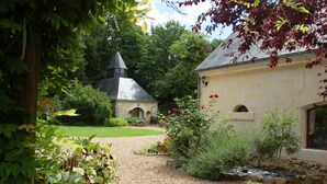 A garden with a stone building, a small pond, and various plants. - Luxury gites & B&B, near Saumur, in 18thC former wine estate, heated pool  (Les Bois D'anjou, Pays De La Loire)
