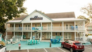 Ein zweistöckiges Hotel mit Poolbereich und Außenbereich zum Sitzen.