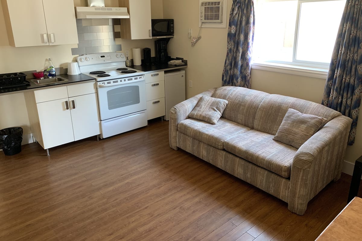 A compact kitchen with a stove, microwave, and a small dining area.