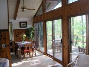 Enjoy meals at the dining table, surrounded by a potted plant and forest views.