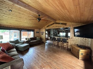 A spacious wooden cabin with a living room, kitchen, and bar area. - Best Lake in Southwest Michigan! Pontoon Boat included. Private beach frontage. (Grand Junction)