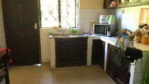 A kitchen with a sink, a microwave, and a fan.