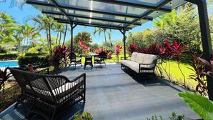 An outdoor patio with a glass roof, surrounded by lush greenery and a pool. - 3-BR Villa, 5 min to Beach, AC, WiFi, Private Pool & Rancho, Esterillos Este (Esterillos Este)