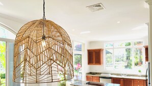 A modern kitchen with a large island, wooden cabinets, and a hanging light fixture. - 3-BR Villa, 5 min to Beach, AC, WiFi, Private Pool & Rancho, Esterillos Este (Esterillos Este)
