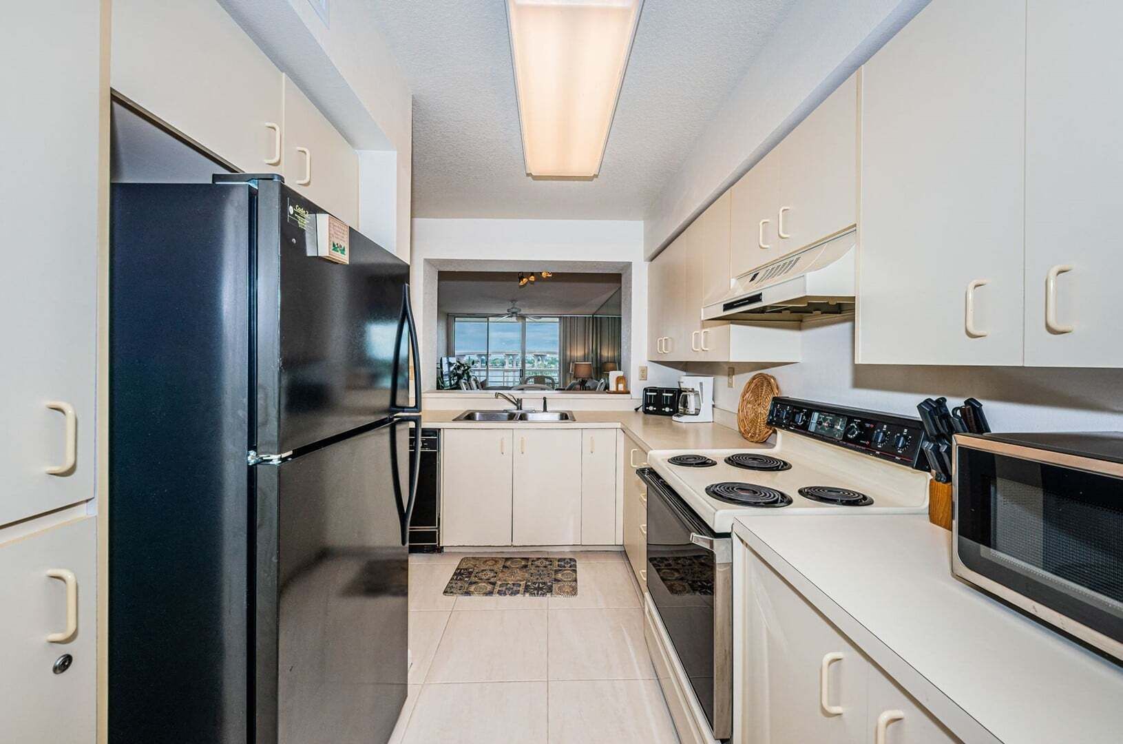Une cuisine moderne équipée d’un réfrigérateur, d’une cuisinière, d’un four à micro-ondes et de placards.