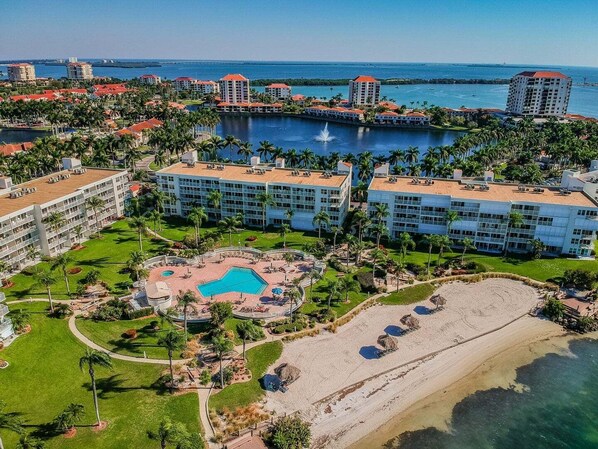 A resort with multiple buildings, a swimming pool, and a beach.