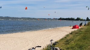 A beach with a bicycle and a red tent. - Luxury Holiday Home, Large Garden, Free Motorboat Usage for Our Guests (Medemblik)