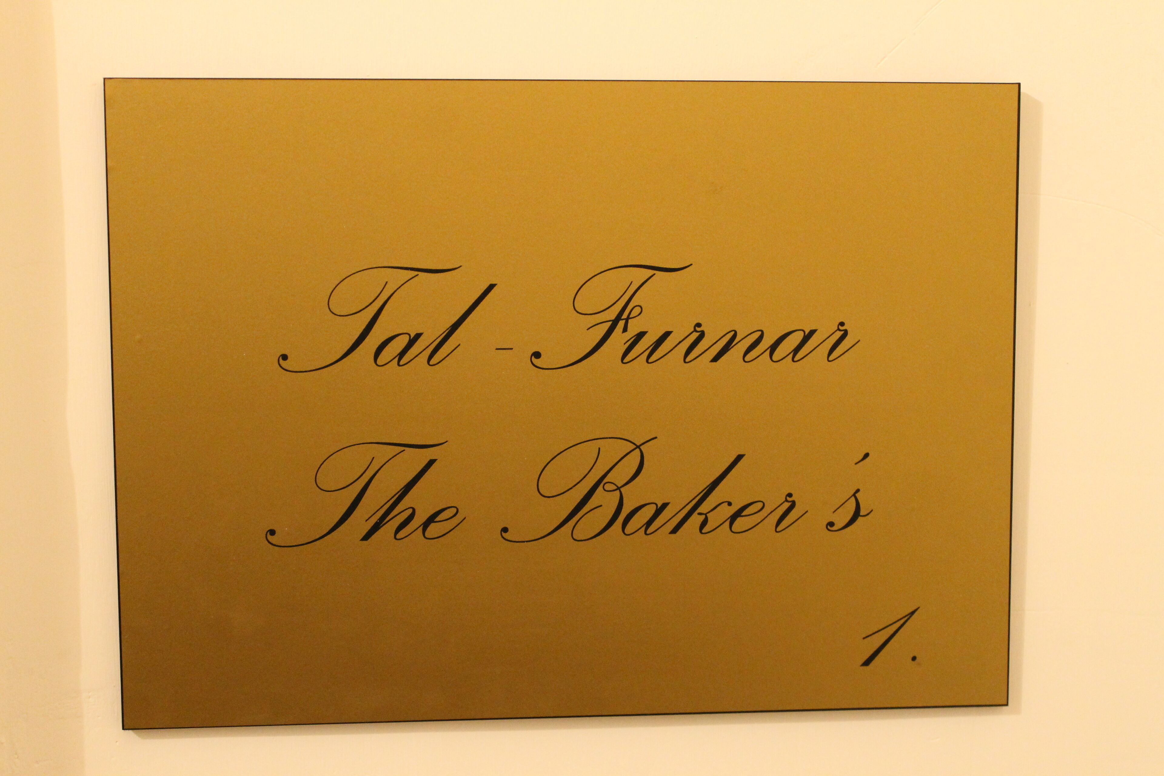Een bord met de tekst 'Tal-Furmar The Baker's 1'.