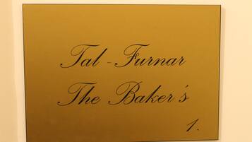 Een bord met de tekst 'Tal-Furmar The Baker's 1'.