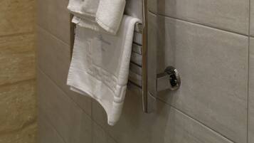 Un baño con un perchero que sostiene varias toallas blancas.