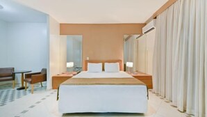 A hotel room with a large bed, bedside tables with lamps, a sofa, and a checkered floor. - Hotel Nacional Inn Cuiabá (Cuiabá)