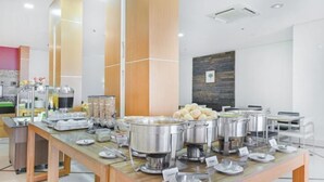 A buffet setup with various food items and serving utensils on a wooden table. - Hotel Nacional Inn Cuiabá (Cuiabá)
