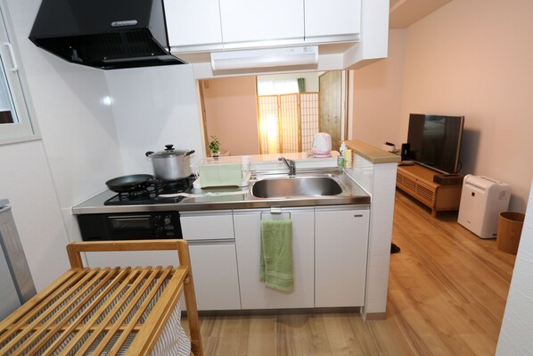 A compact kitchen with a stove, sink, and a small dining area.