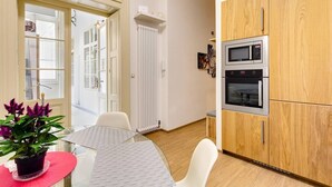 Een moderne keuken met houten kastjes, een ingebouwde magnetron en een dubbele oven.