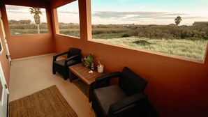 A room with a view of a field, a table, two chairs, and a small plant. - Steps to the Beach! Rooftop Deck! Firepit & BBQ! (Oceano)