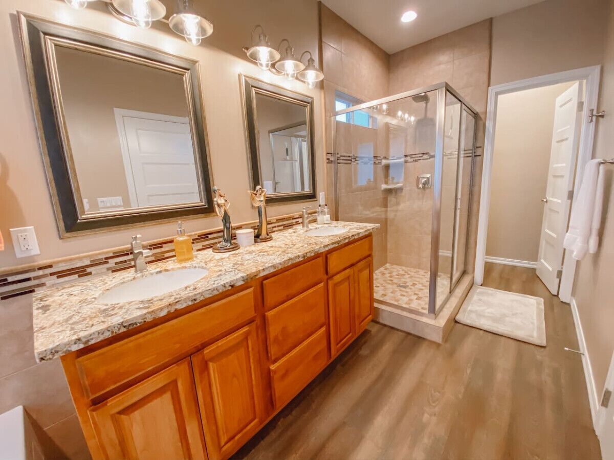 A bathroom with a double vanity, a glass shower enclosure, and a walk-in shower.
