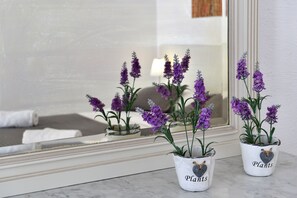 Two potted plants with the word "Plants" on them, placed on a marble surface near a window with a reflection of a room.