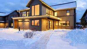 A modern two-story house with a covered porch and a snow-covered driveway. - Luxury + views ~ 7 mins to downtown ~ resort ~ hot tub ~ wifi ~ BBQ ~ Bend ~ 🐶 (Bend)