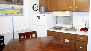 Una cocina compacta con armarios de madera, un refrigerador, una estufa y un lavamanos.