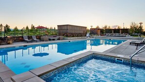 A rectangular swimming pool with a tiled edge, surrounded by lounge chairs and a covered seating area. - Bring your 🚲~ resort pool ~ amenities ~ trails ~ golf ~ hot tub ~ Bend ~ 🐶 (Bend)
