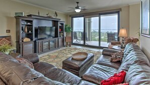 Ein geräumiges Wohnzimmer mit Ledersofa, Flachbildfernseher und einem Balkon mit Aussicht.