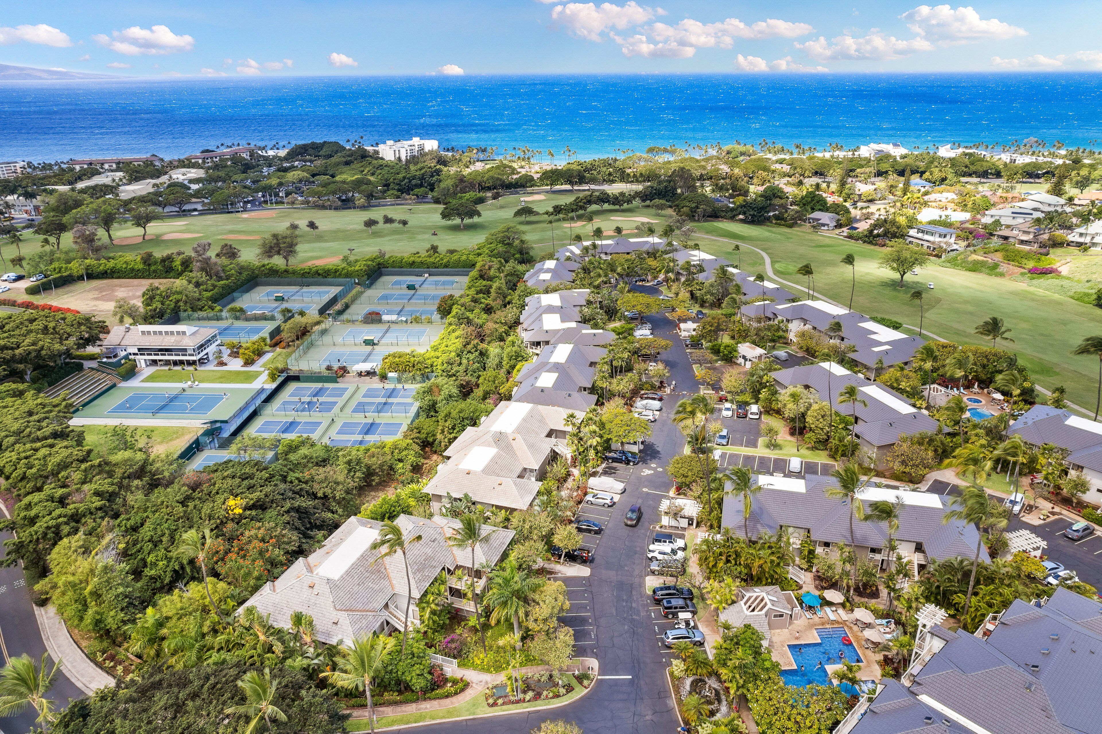 Vista aérea de una zona residencial con casas, cancha de tenis y piscina.