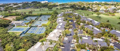 Vista aérea de una zona residencial con casas, cancha de tenis y piscina.