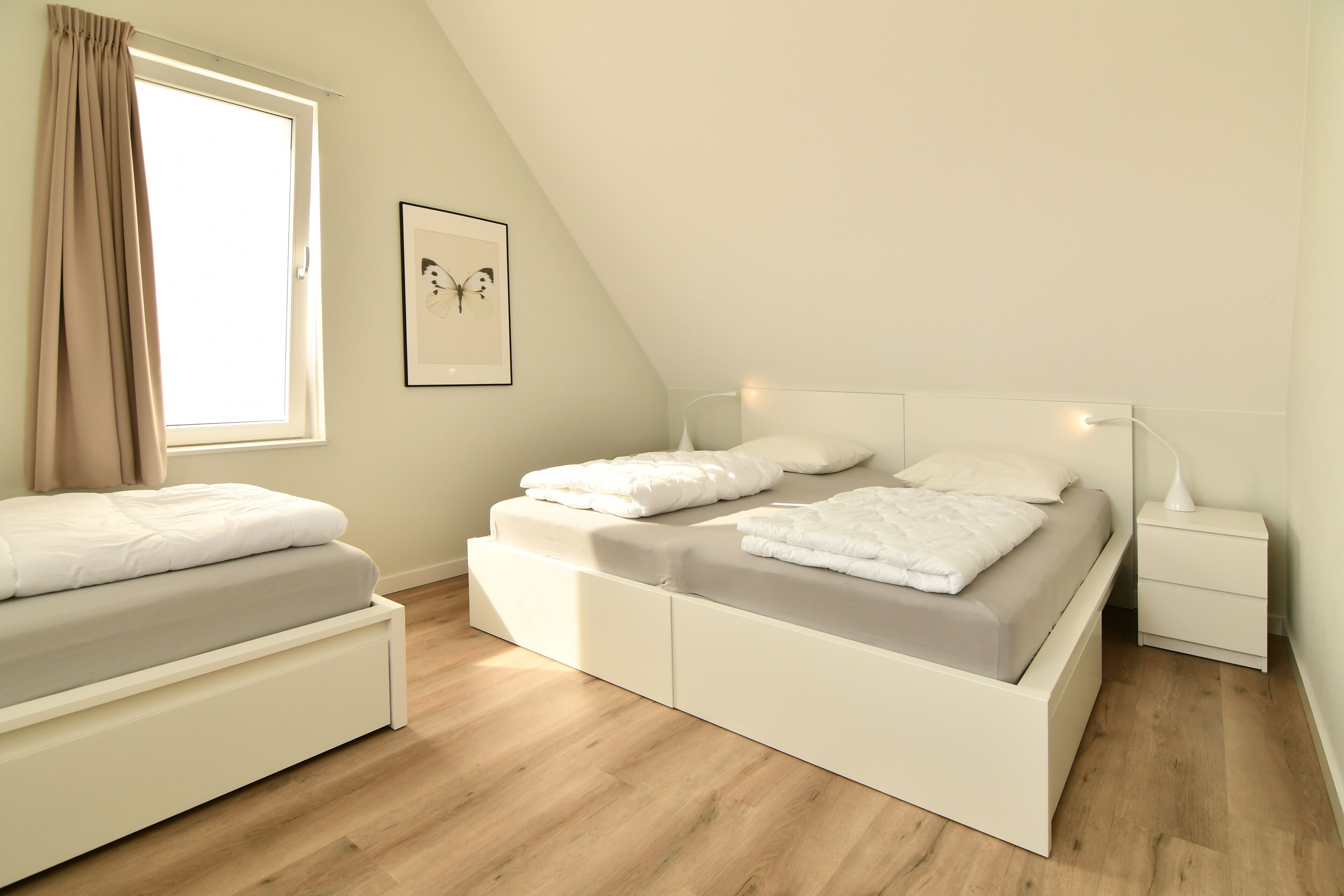 Een moderne slaapkamer met een hoogslaper, nachtkastje en raam met gordijnen.