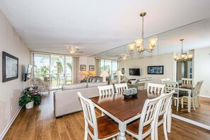 A spacious living area with a dining table, sofas, and a TV.